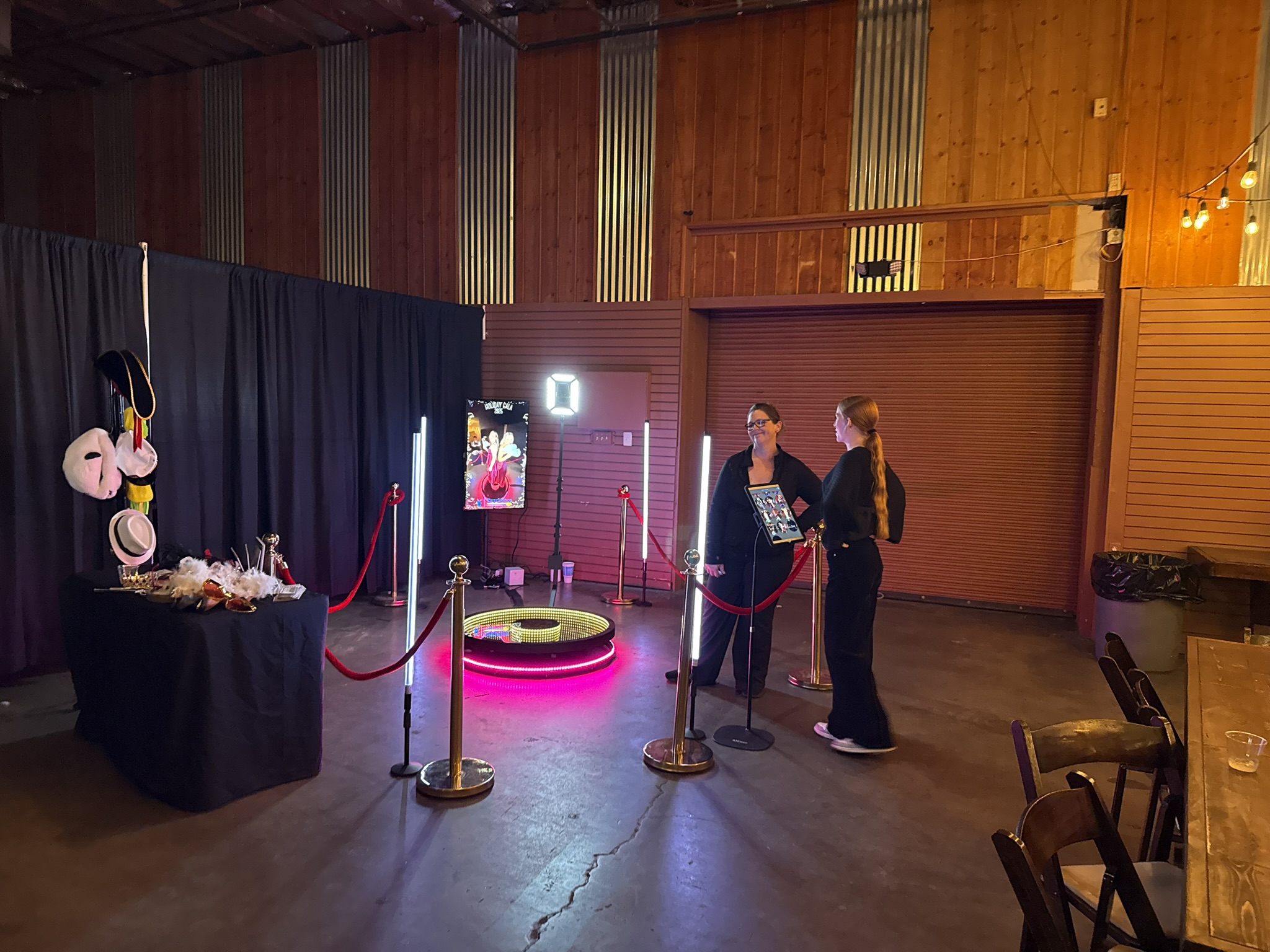 360 video booth with red carpet and LED light poles at a barn venue